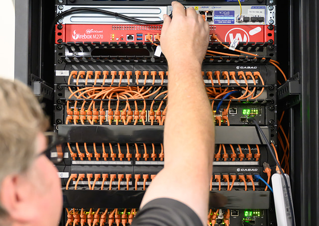 it infrastructure support, plugging new cable into server rack
